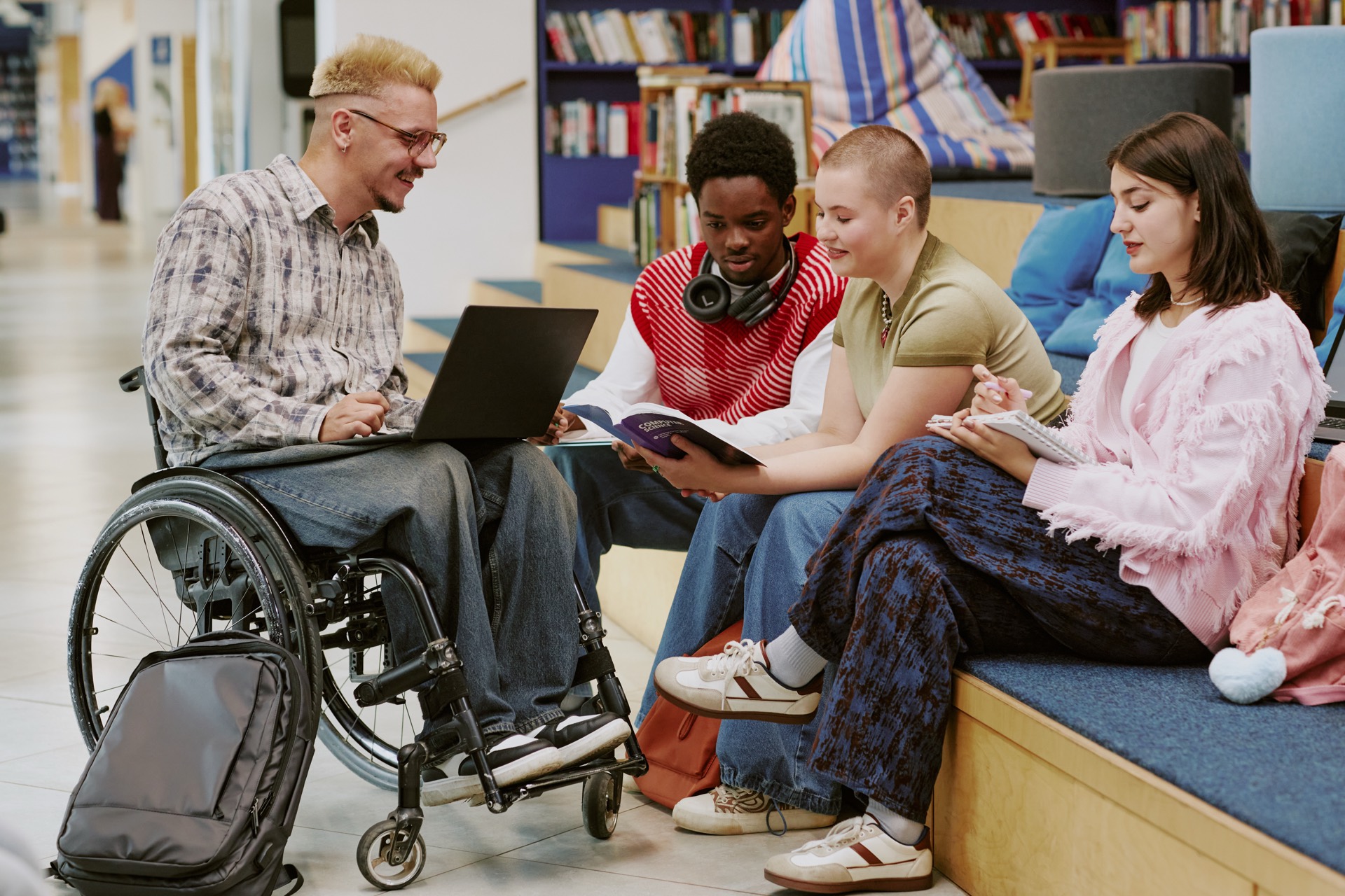 Students and researchers collaborating in a bright modern library utilizing technology tools and papers