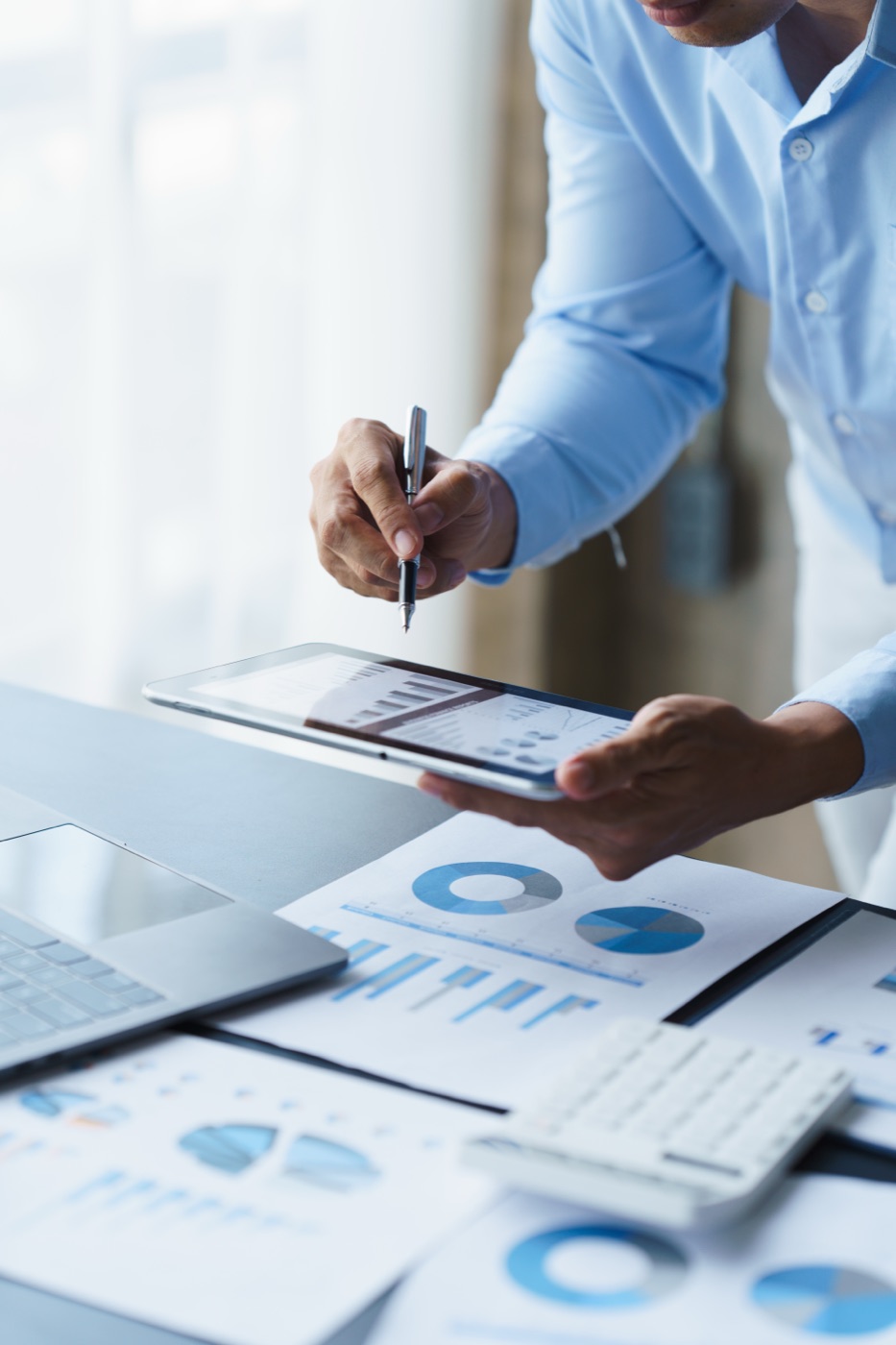 Professional analyzing charts and data at a desk