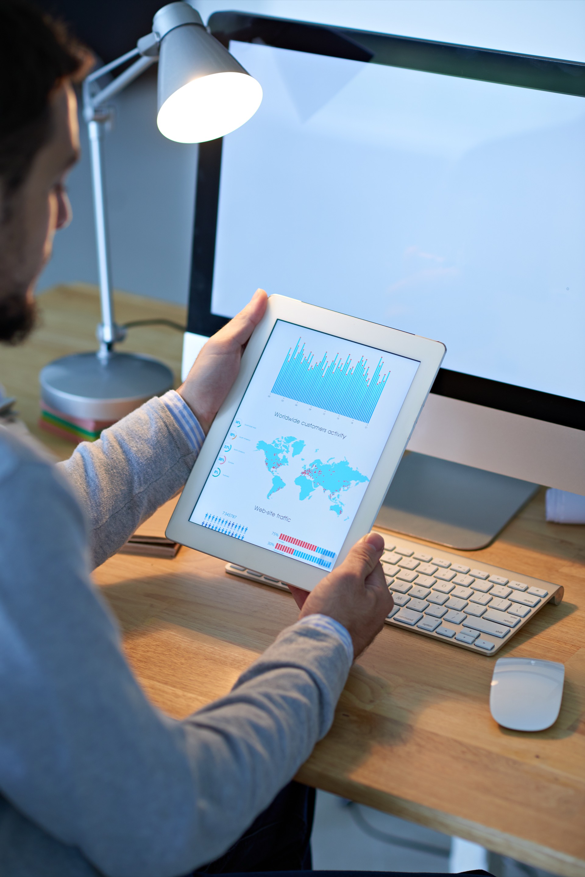 IT Specialist analyzing complex business charts and graphs on a tablet screen in a dashboard